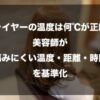 美容室で座っているロングヘアの女性の後ろ姿を背景に、「ドライヤーの温度は何℃が正解？」という疑問と、それに対する答えとして「美容師が『傷みにくい温度・距離・時間』を基準化」したことを伝えるタイトル文字が配置されています。髪を熱ダメージから守る正しい乾かし方の基準を解説する記事のアイキャッチ画像です。
